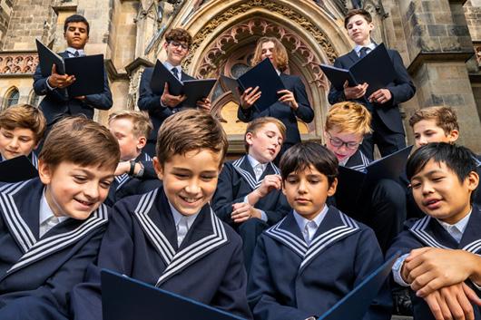 Group of younger people in front of church with open choir books